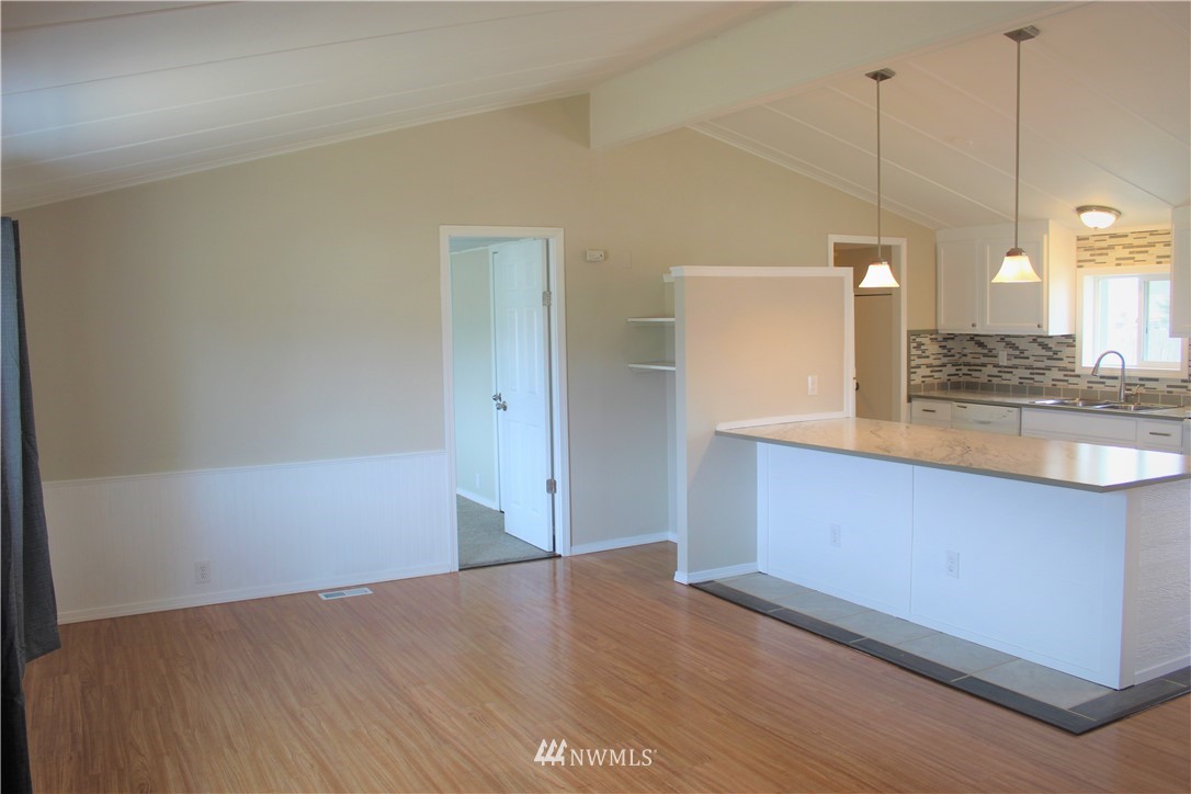 41 Sand Flat Road Omak, WA 98841 - Photo 5 of 18 a kitchen with granite countertop white cabinets and wooden floor