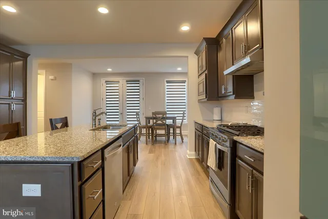 a kitchen with stainless steel appliances granite countertop a stove a sink and a microwave