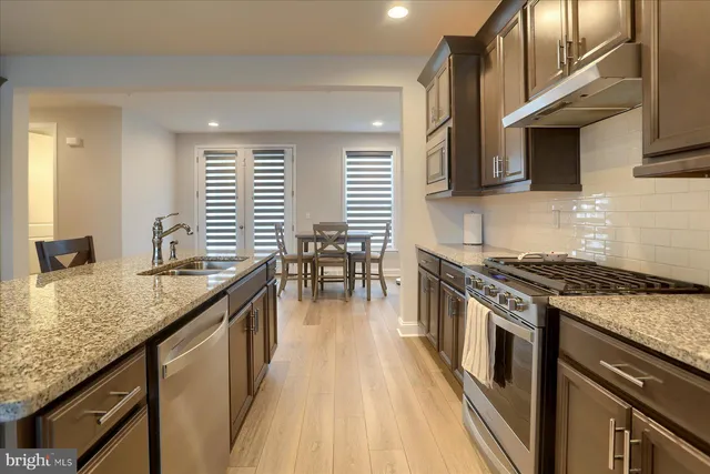 a kitchen with stainless steel appliances granite countertop a stove and a sink
