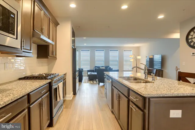 a kitchen with granite countertop a sink stove and cabinets