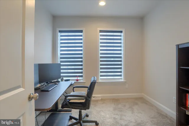 a view of a workspace with furniture and a window