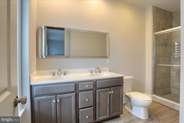 a bathroom with a toilet a sink a mirror and shower