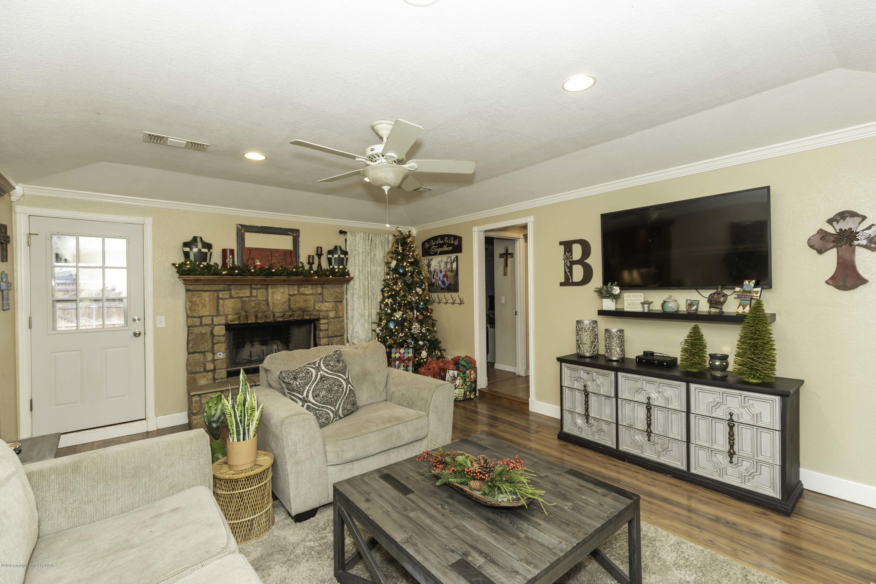 5308 Wheeler Lane Amarillo, TX 79110 - Photo 7 of 41 a living room with furniture a flat screen tv and a fireplace