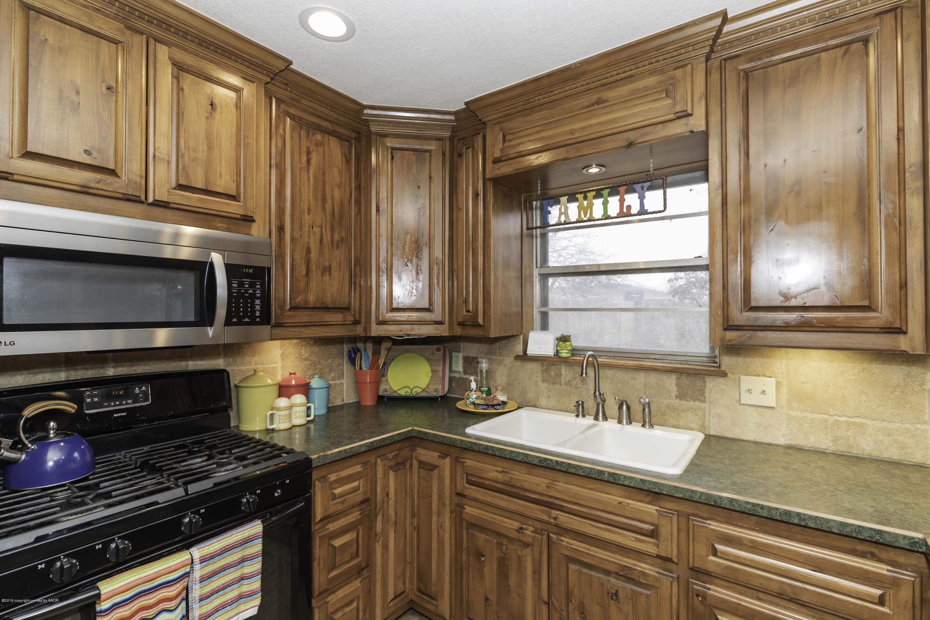 5308 Wheeler Lane Amarillo, TX 79110 - Photo 10 of 41 a kitchen with stainless steel appliances granite countertop a sink a stove and a microwave