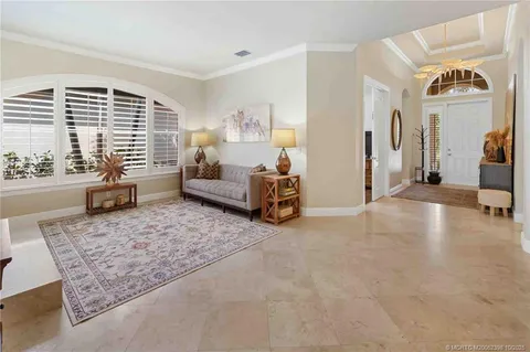 a living room with furniture a rug a fireplace and a large window