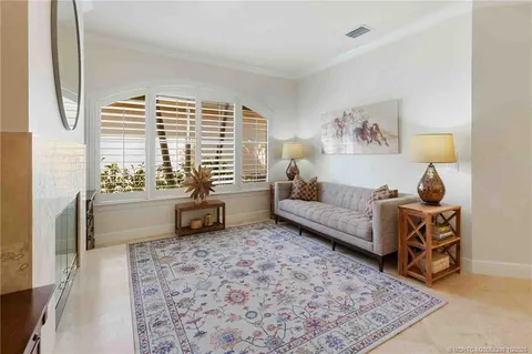 a kitchen with stainless steel appliances granite countertop a sink a stove a refrigerator cabinets and a dining table with wooden floor