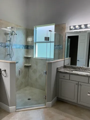 a bathroom with a shower sink and mirror