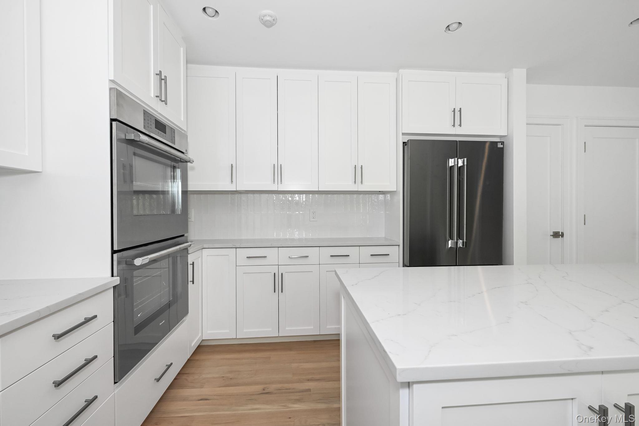 24 Country Road Mamaroneck, NY 10543 - Photo 7 of 37 a kitchen with a refrigerator stove and cabinets