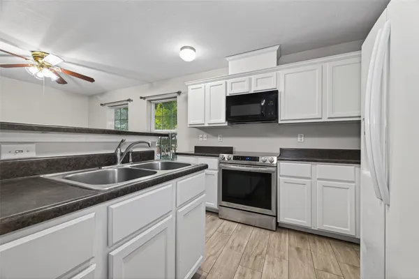 a kitchen with stainless steel appliances granite countertop a sink and a stove