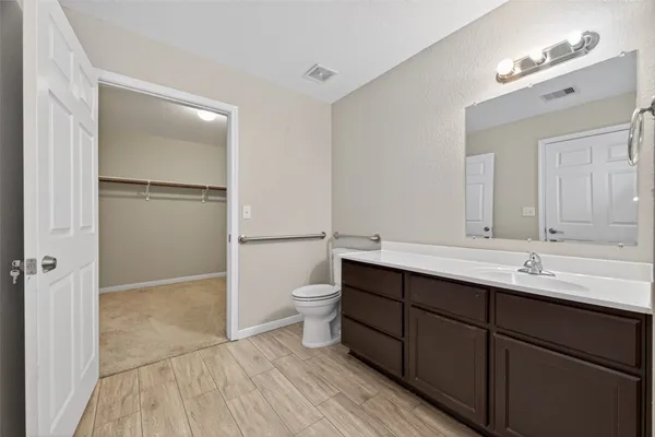 a bathroom with a double vanity sink mirror and toilet