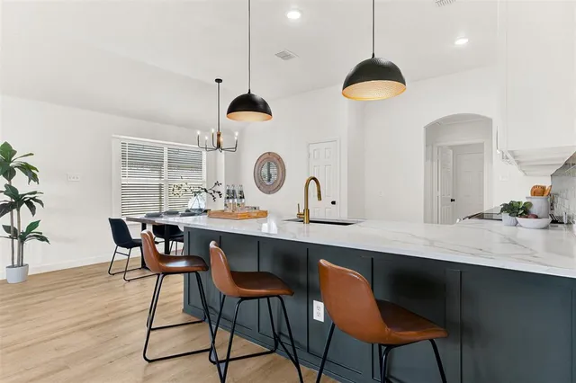 a kitchen with stainless steel appliances a table chairs and a chandelier