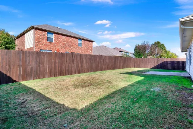 a view of an house with backyard and a tree