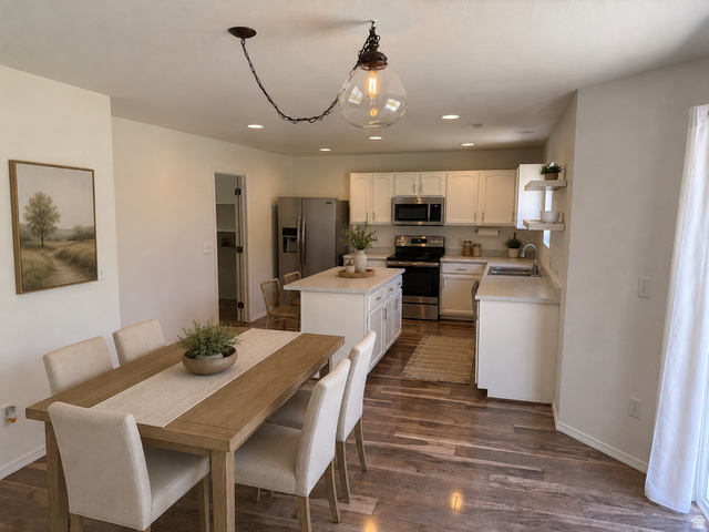 1038 West 950 South Springville, UT 84663 - Photo 7 of 14 Open-concept kitchen and dining area featuring wood-finish flooring, white cabinetry, a kitchen island, and recessed lighting