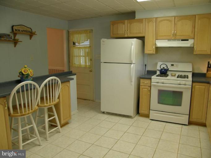6221 Commons Road Rosedale, MD 21237 - Photo 7 of 27 a kitchen with a stove top oven and cabinets