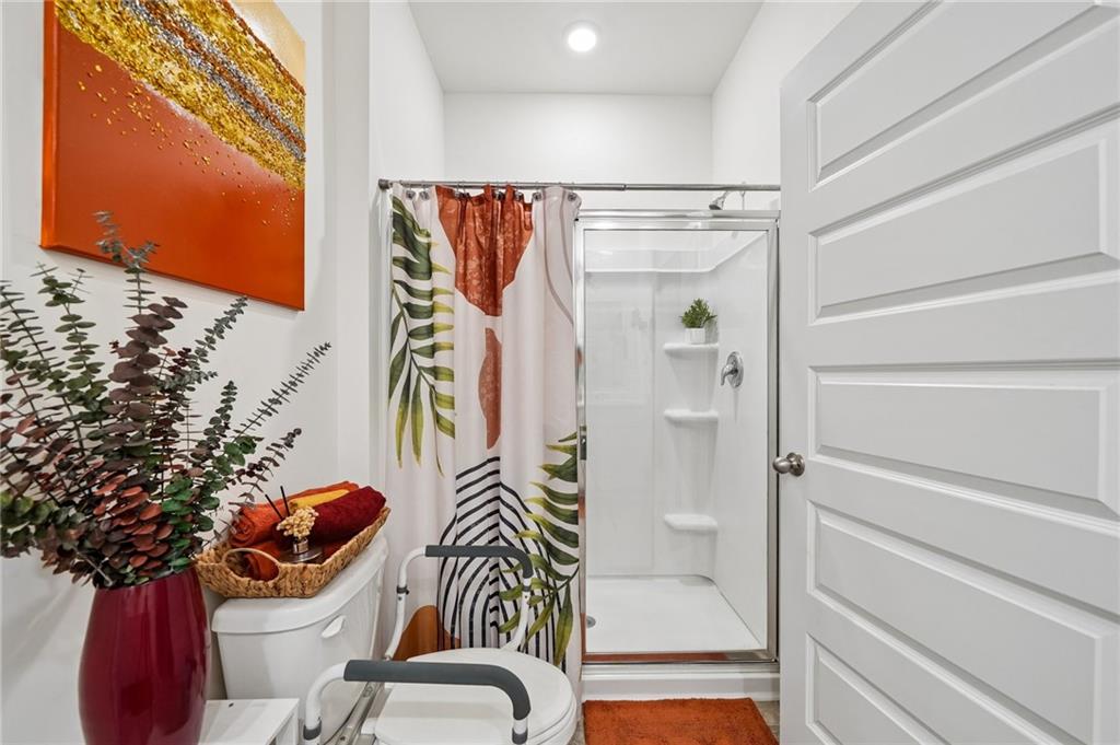 8592 Seabiscuit Road Lithonia, GA 30058 - Photo 12 of 25 a bathroom with a toilet and shower curtain