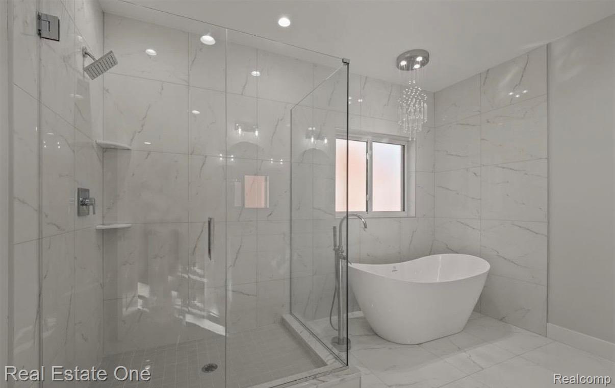5636 Paris Street Sterling Heights, MI 48310 - Photo 16 of 37 Full bathroom featuring a marble finish shower, a freestanding tub, and marble tiled flooring
