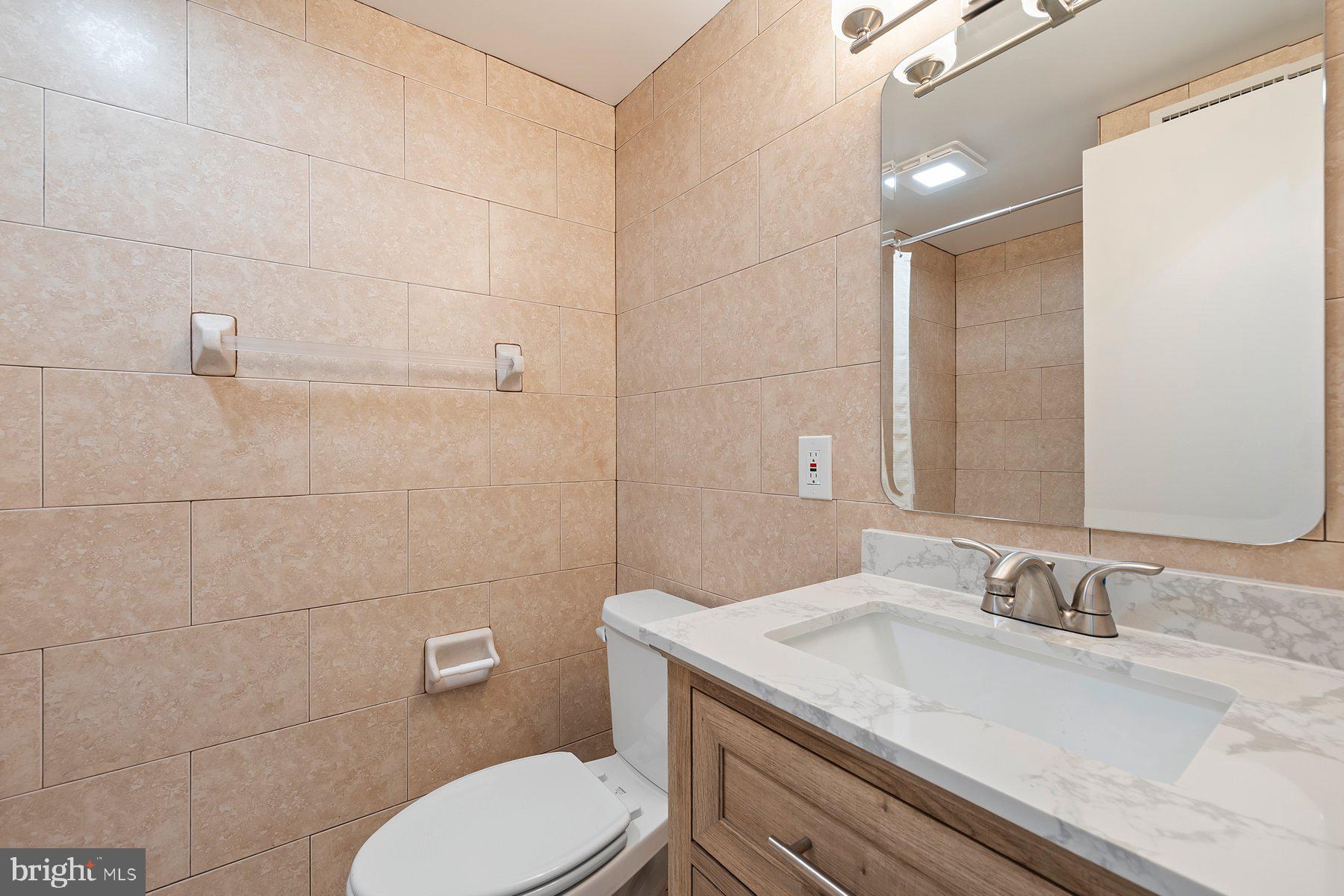 18604 Muncaster Road Rockville, MD 20855 - Photo 62 of 90 a bathroom with a granite countertop sink a toilet and a mirror