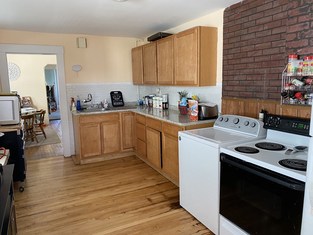 285 High Street Lowell, MA 01852 - Photo 5 of 8 a kitchen with a stove and white cabinets