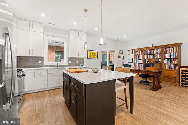 a kitchen with stainless steel appliances granite countertop a table chairs stove microwave and cabinets