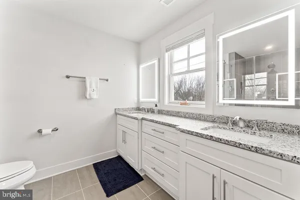 a bathroom with a granite countertop sink toilet and shower