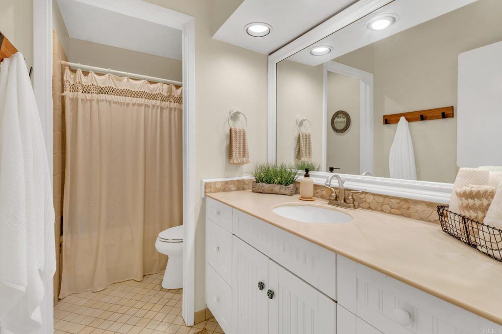 1528 Juniperhill Drive Encinitas, CA 92024 - Photo 18 of 40 a bathroom with a granite countertop sink and a mirror