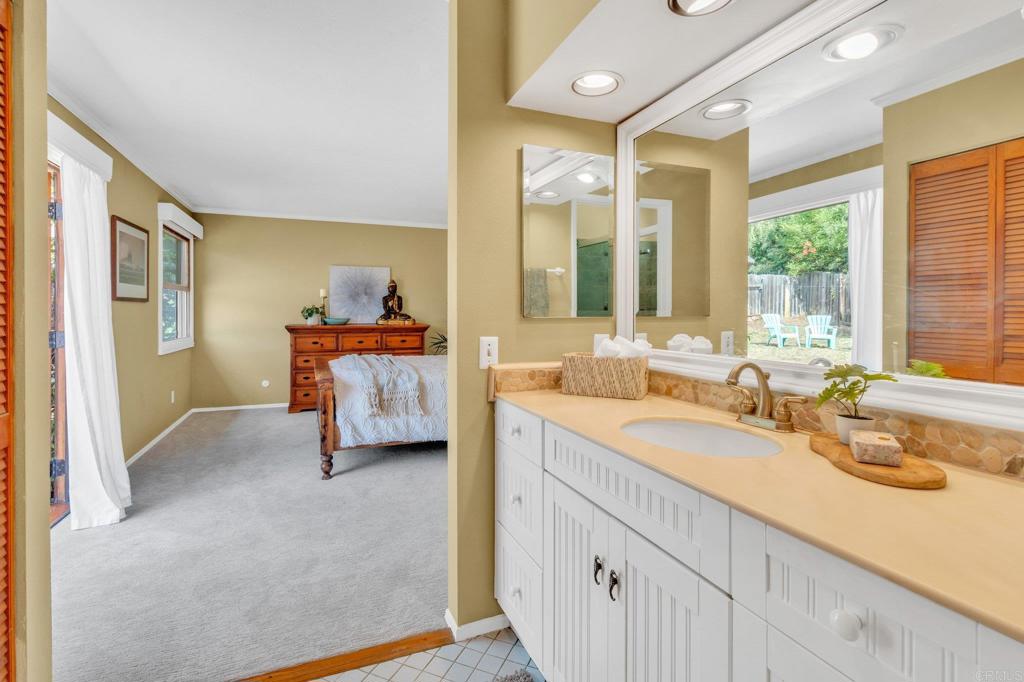 1528 Juniperhill Drive Encinitas, CA 92024 - Photo 23 of 40 a en suite bathroom with a double vanity sink large mirror and a bathtub