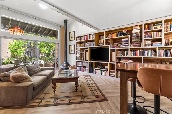 a living room with furniture a flat screen tv and floor to ceiling window