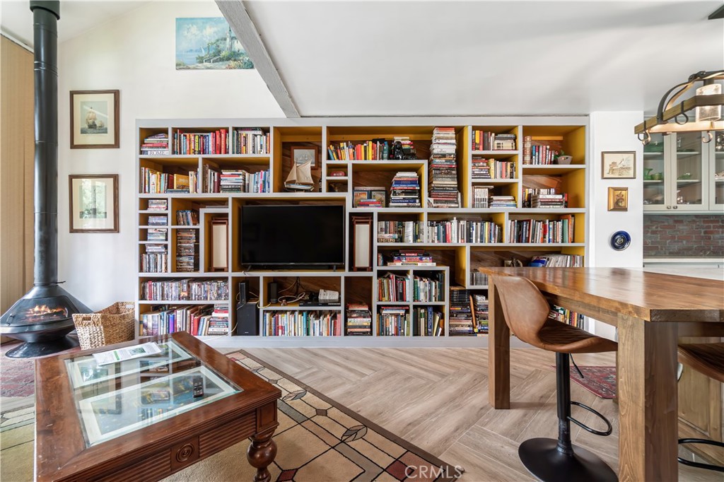 7890 East Spring Street, Unit 14A Long Beach, CA 90815 - Photo 16 of 43 a living room with furniture a rug and a book shelf