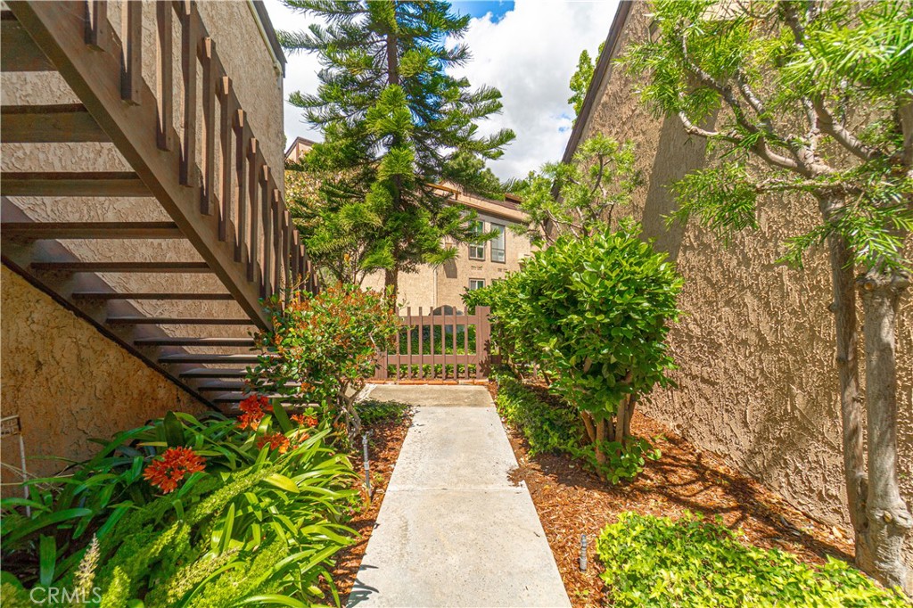 7890 East Spring Street, Unit 14A Long Beach, CA 90815 - Photo 9 of 43 a view of a pathway with flower plants in front of main door