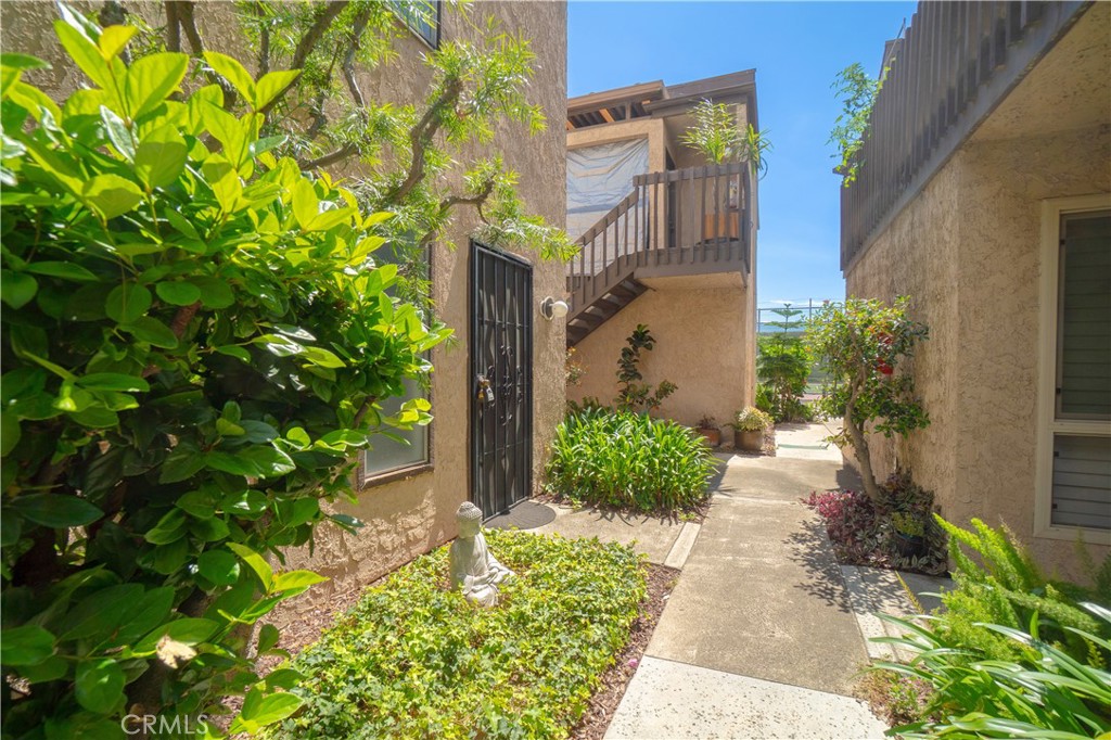 7890 East Spring Street, Unit 14A Long Beach, CA 90815 - Photo 10 of 43 a pathway of a house with a yard and garden