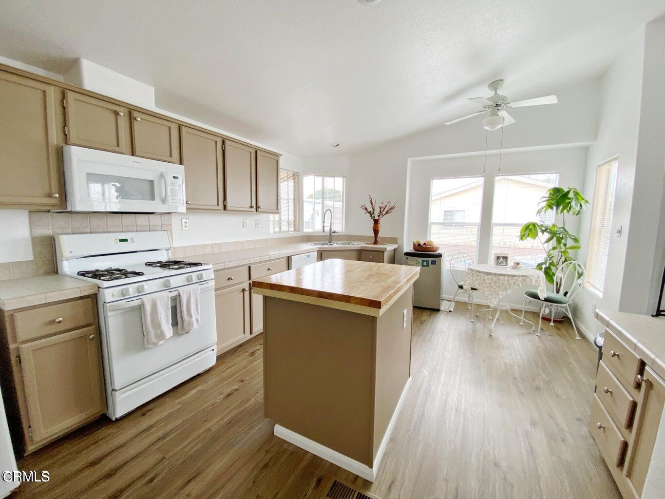 a kitchen with stainless steel appliances a white cabinets and wooden floor