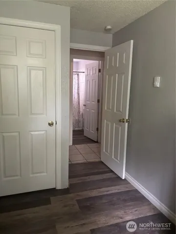 a view of a hallway with wooden floor and closet area