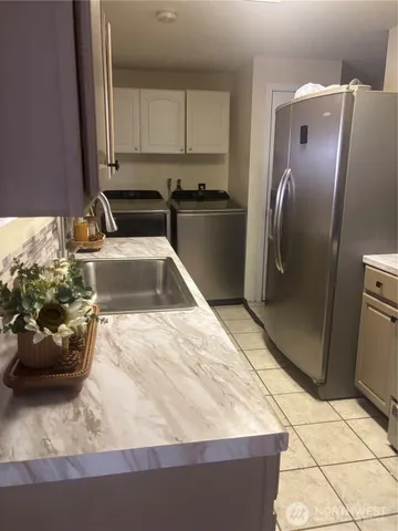 a kitchen with stainless steel appliances kitchen island granite countertop a refrigerator a stove and a sink