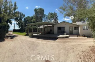 a view of a house with a yard and large tree