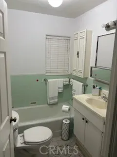 a bathroom with a granite countertop toilet sink and mirror