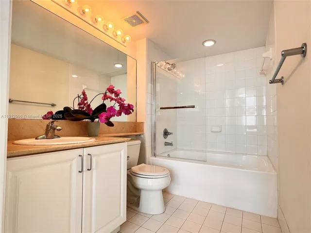 a bathroom with a sink vanity mirror and toilet