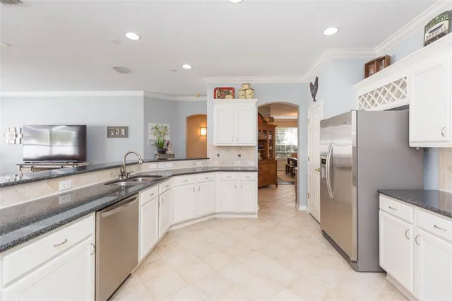a kitchen with stainless steel appliances granite countertop a refrigerator and a stove top oven