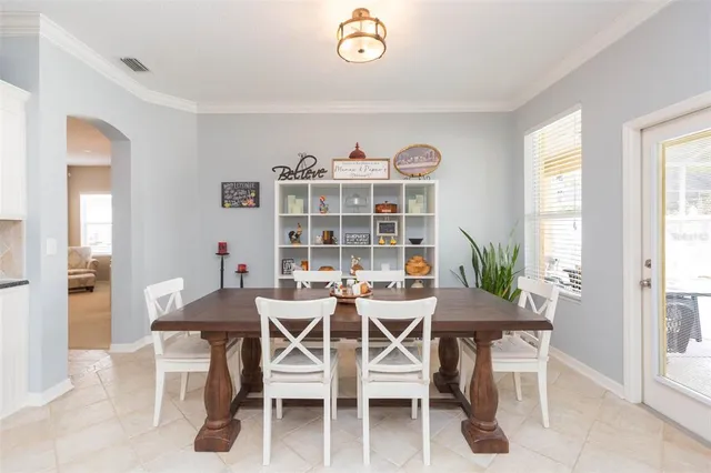 a living room with furniture kitchen view and a chandelier