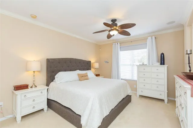 a bedroom with a bed a chandelier and a dresser