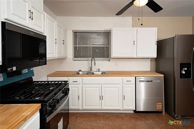 a kitchen with granite countertop a stove sink and cabinets