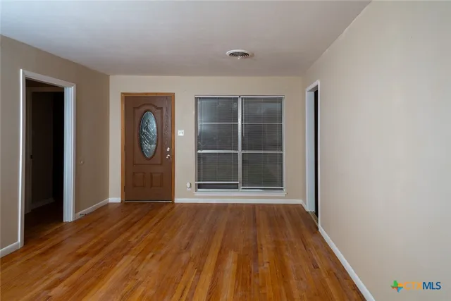 a view of a room with wooden floor