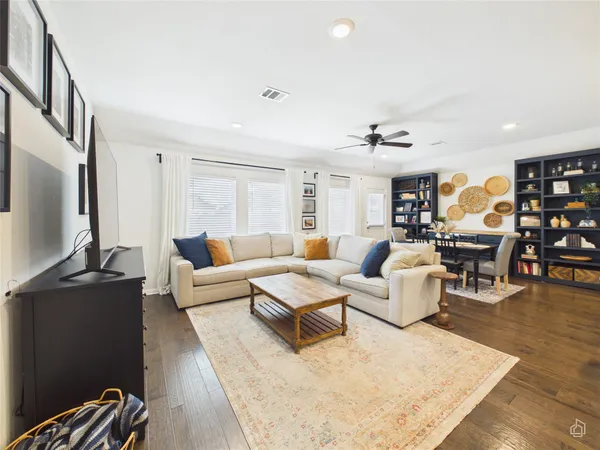 a living room with furniture kitchen view and a flat screen tv