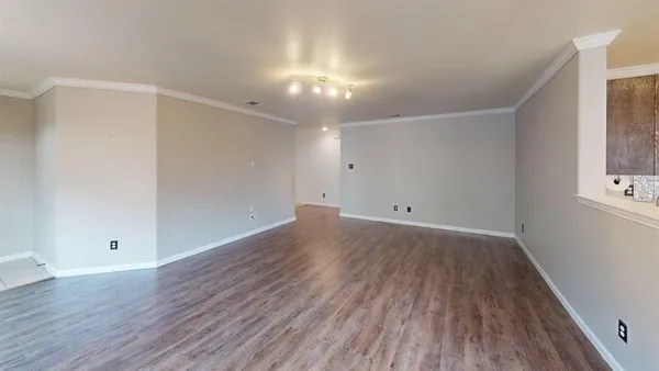 a view of an empty room with wooden floor