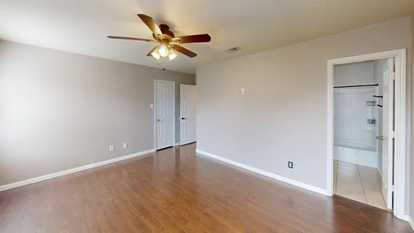 a view of an empty room with wooden floor