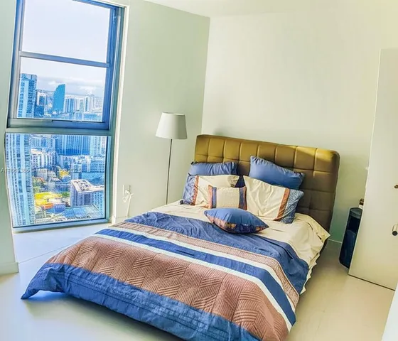 a bedroom with a bed and painting on the wall