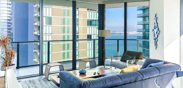 a living room with furniture and a floor to ceiling window