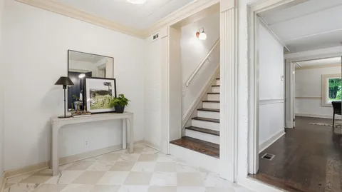 a view of a hallway that has closet with wooden floor