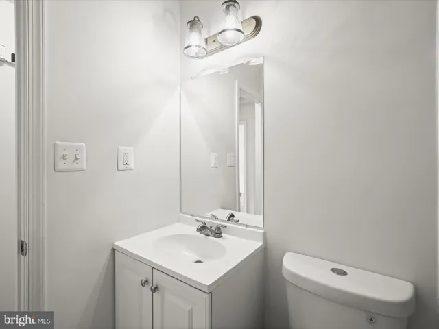 a bathroom with a toilet a sink and mirror