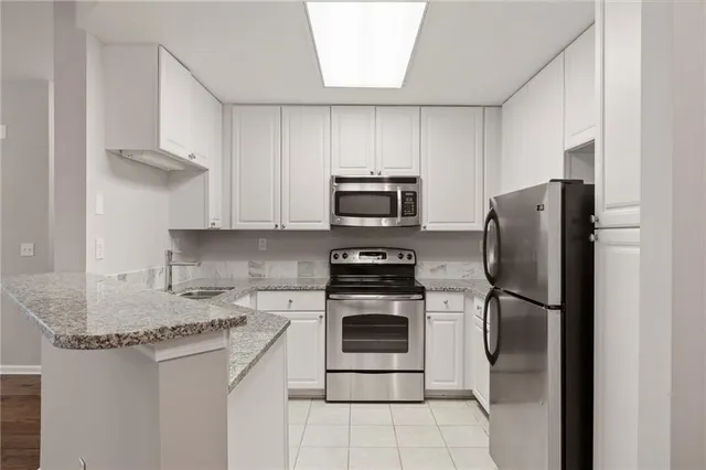 a kitchen with stainless steel appliances granite countertop a refrigerator stove and microwave