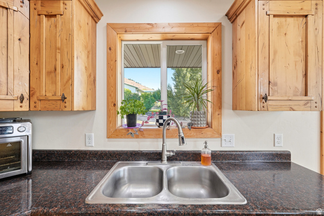 306 Spring Road Preston, ID 83263 - Photo 12 of 55 Kitchen workstation featuring a double basin stainless steel sink with a high-arch faucet, set into a dark speckled countertop